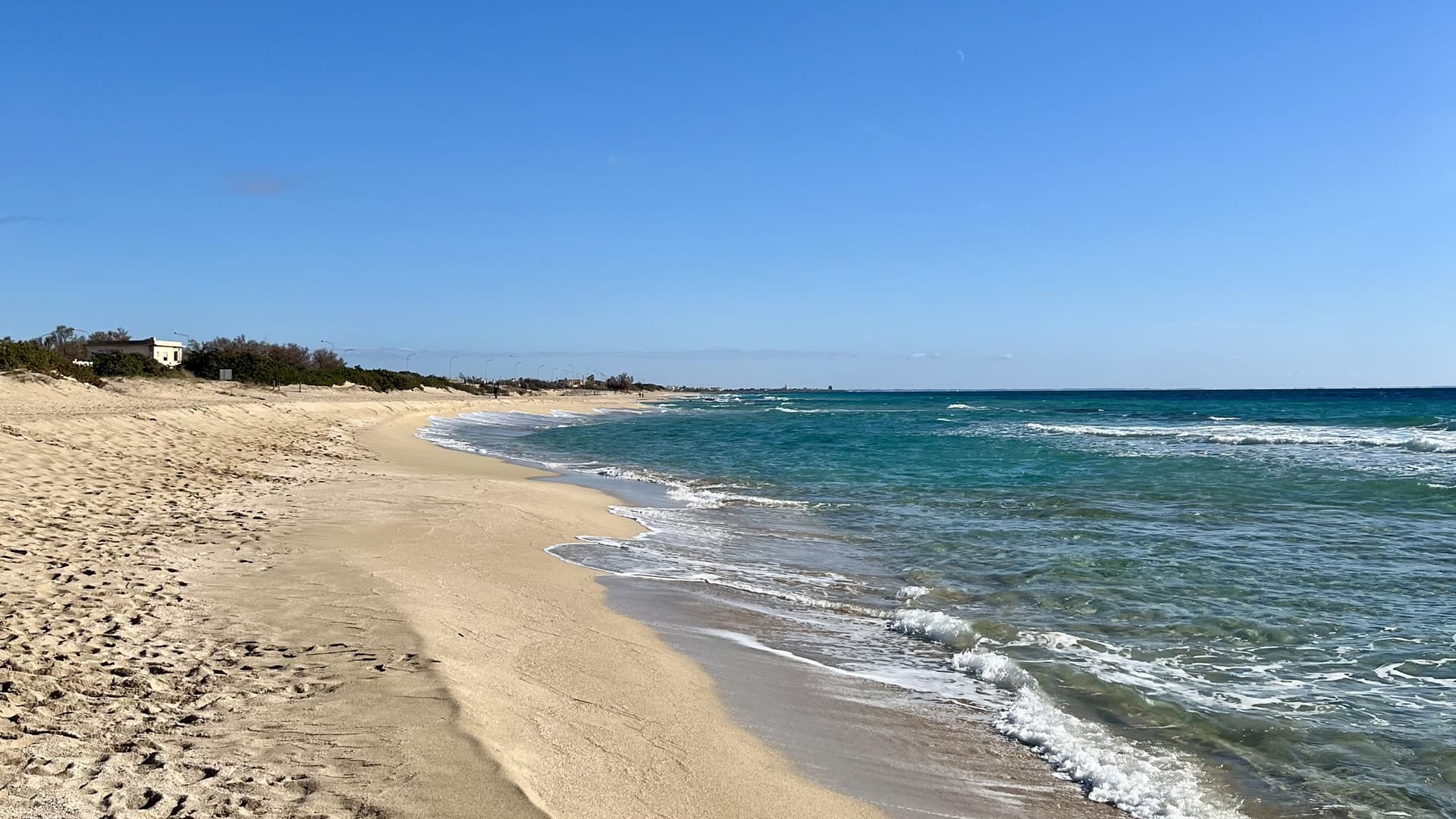 Spiaggia lunga e deserta, con le onde che arrivano a riva